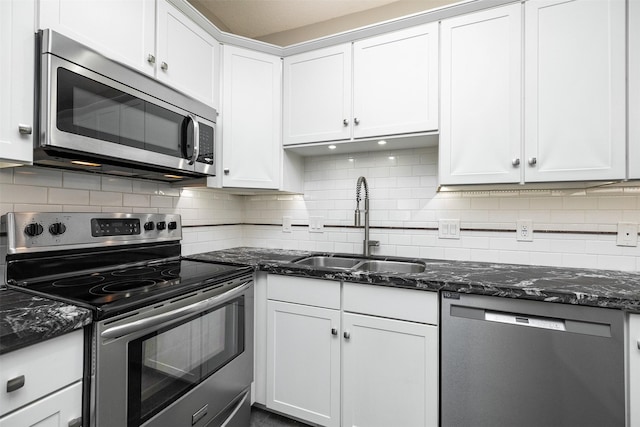 kitchen with tasteful backsplash, sink, white cabinets, dark stone counters, and stainless steel appliances