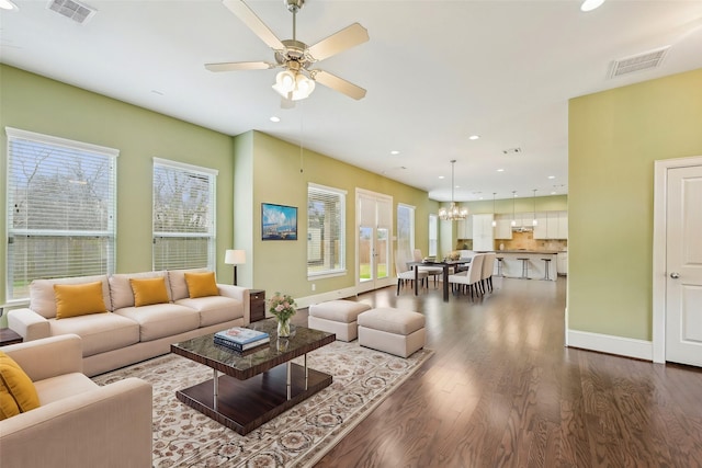 living area featuring baseboards, visible vents, wood finished floors, and recessed lighting