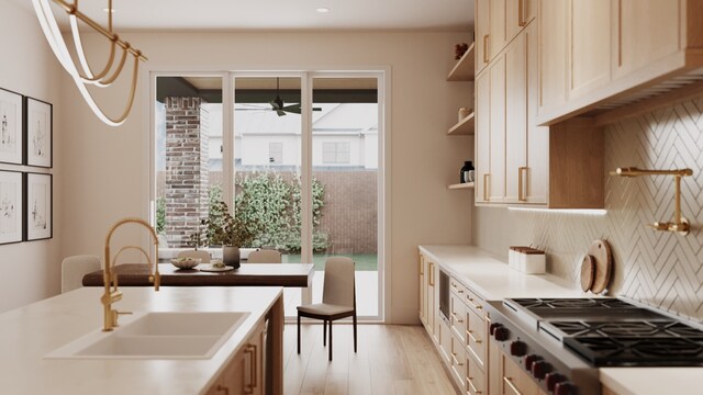 kitchen with sink, ceiling fan, backsplash, light hardwood / wood-style floors, and stainless steel gas cooktop