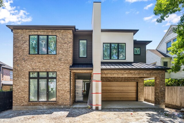 1615 Milford St, Houston, TX 77006 - contemporary house with brick siding, a standing seam roof, fence, and a garage