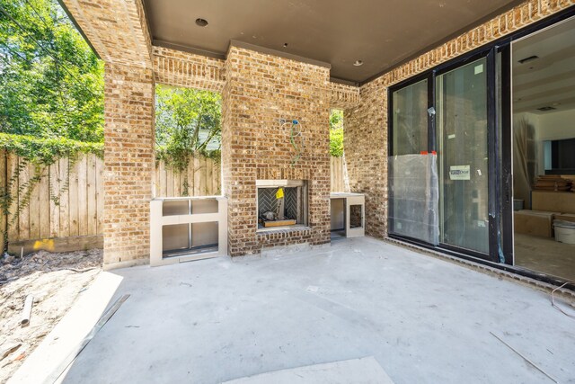 1615 Milford St, Houston, TX 77006 - view of patio with an outdoor brick fireplace and fence
