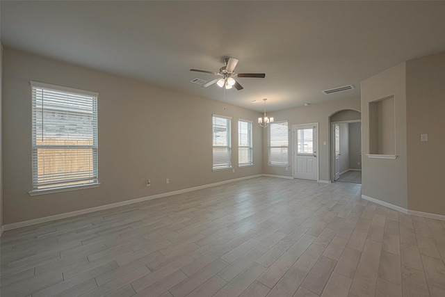 empty room featuring ceiling fan with notable chandelier and light wood-type flooring