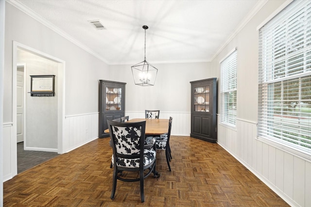 dining room featuring crown molding, a chandelier, and dark parquet floors