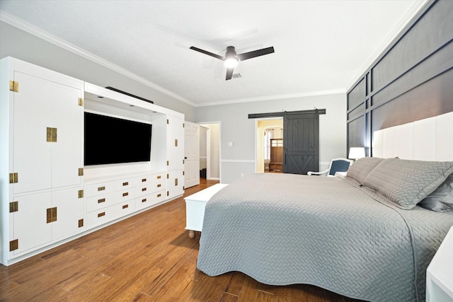 bedroom with ornamental molding, a barn door, hardwood / wood-style floors, and ceiling fan