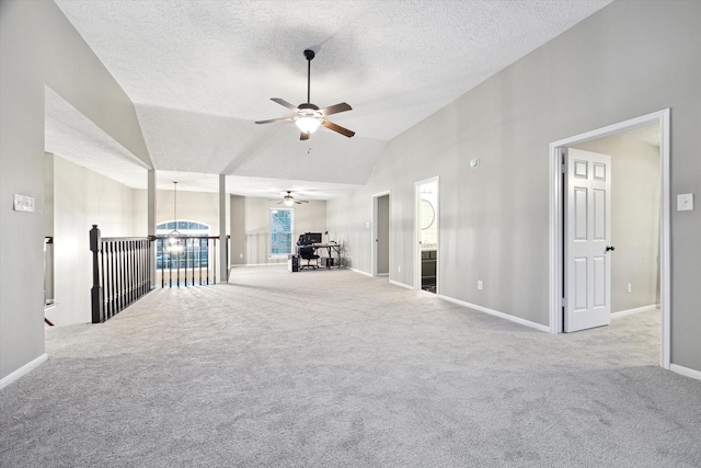 spare room featuring high vaulted ceiling, ceiling fan with notable chandelier, light carpet, and a textured ceiling