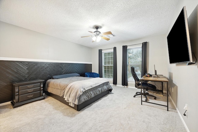 carpeted bedroom with ceiling fan and a textured ceiling