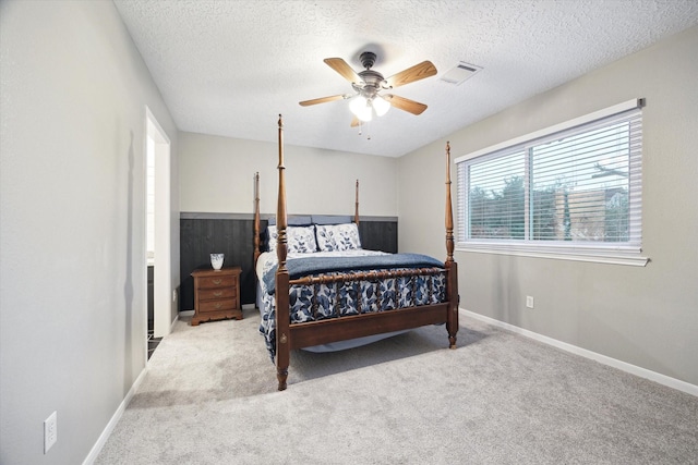 carpeted bedroom with ceiling fan and a textured ceiling