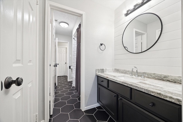 bathroom with tile patterned floors, vanity, and a textured ceiling