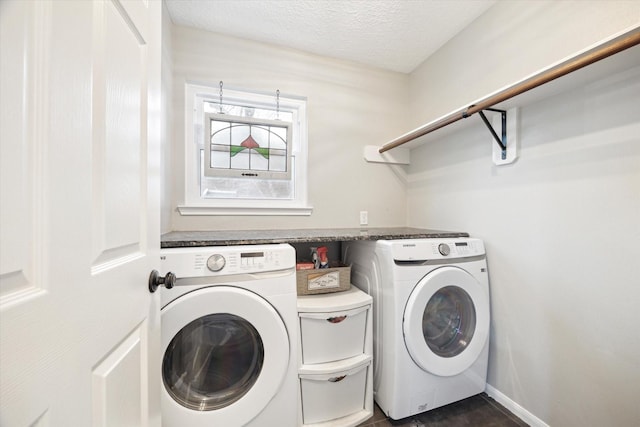 washroom with a textured ceiling and washer and clothes dryer