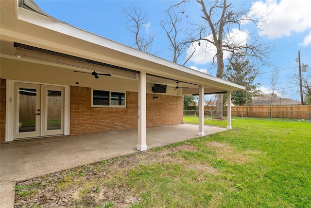 view of yard with a patio, ceiling fan, and french doors