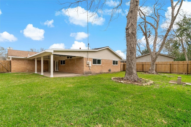 back of property featuring a yard and a patio area