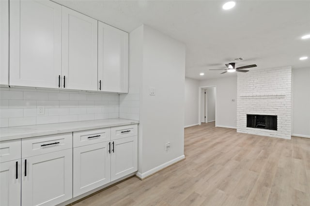 kitchen featuring white cabinetry, light hardwood / wood-style floors, and tasteful backsplash