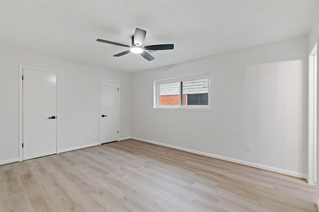 unfurnished bedroom featuring multiple closets, ceiling fan, and light hardwood / wood-style floors