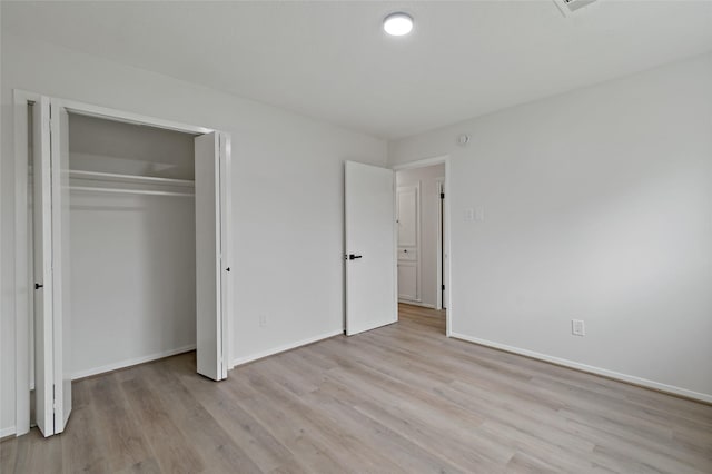 unfurnished bedroom featuring a closet and light hardwood / wood-style flooring