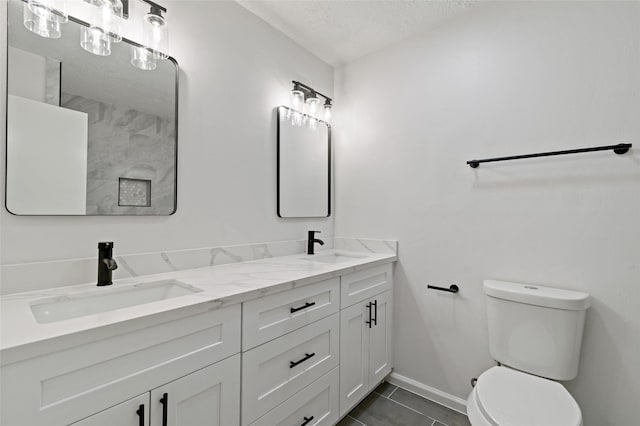 bathroom featuring vanity, a textured ceiling, tile patterned floors, and toilet