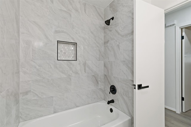 bathroom featuring tiled shower / bath and wood-type flooring