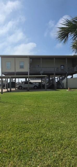 rear view of house featuring a yard and stairs