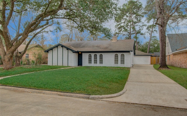 ranch-style house featuring a garage and a front lawn