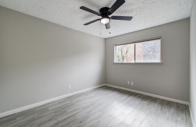 spare room with ceiling fan, a textured ceiling, and light wood-type flooring