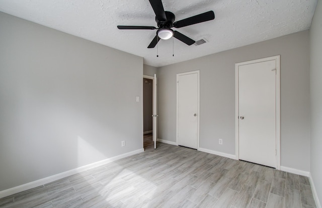 unfurnished bedroom with ceiling fan, a textured ceiling, and light hardwood / wood-style floors