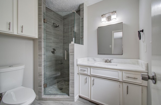 bathroom with walk in shower, vanity, a textured ceiling, and toilet