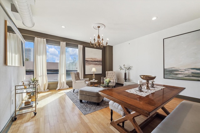 dining space with a chandelier and light hardwood / wood-style floors