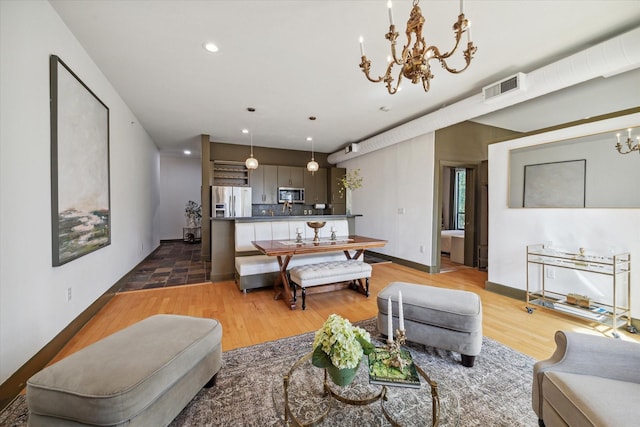 living room featuring a chandelier and light hardwood / wood-style flooring