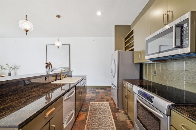 kitchen with appliances with stainless steel finishes, sink, backsplash, dark stone counters, and hanging light fixtures