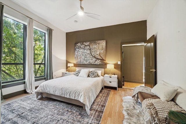 bedroom featuring multiple windows, ceiling fan, and light hardwood / wood-style flooring