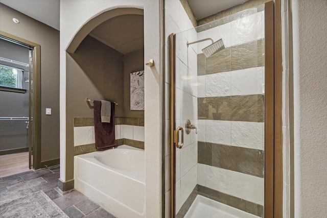 bathroom featuring shower with separate bathtub