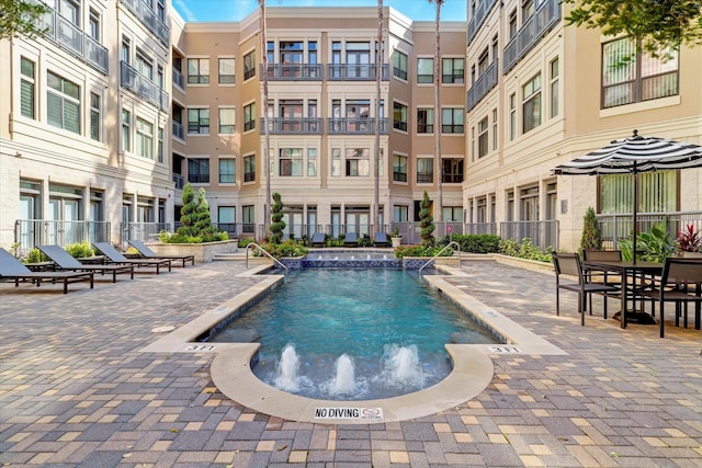 view of swimming pool with pool water feature and a patio area