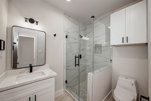 bathroom featuring vanity, an enclosed shower, and toilet