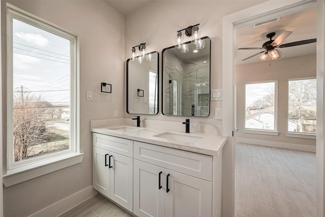 bathroom with vanity, ceiling fan, and a shower with shower door