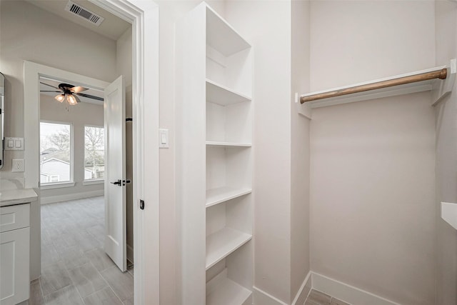 walk in closet featuring ceiling fan