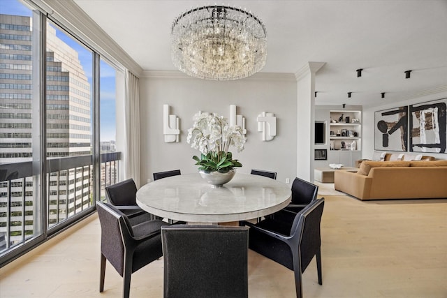 dining space with an inviting chandelier, crown molding, built in features, and light hardwood / wood-style floors