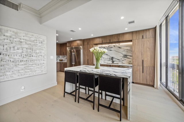 dining area featuring crown molding, sink, and light hardwood / wood-style flooring