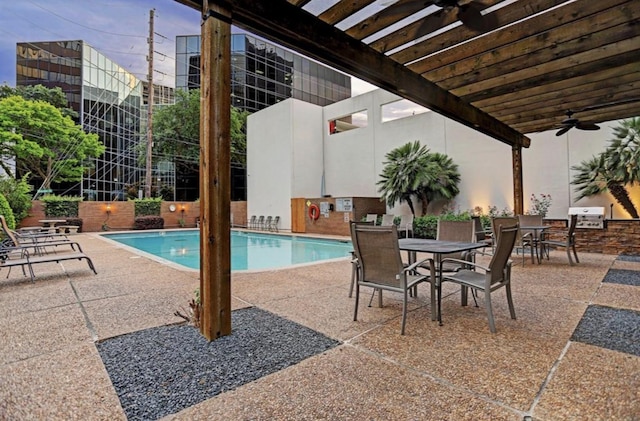 view of pool featuring area for grilling, a patio, ceiling fan, and exterior kitchen