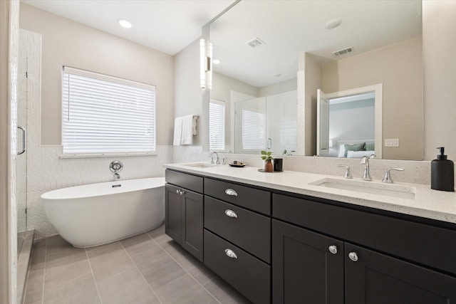 bathroom with tile patterned floors, independent shower and bath, and vanity