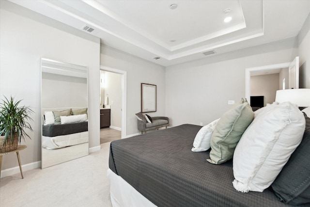 bedroom featuring a tray ceiling and light colored carpet