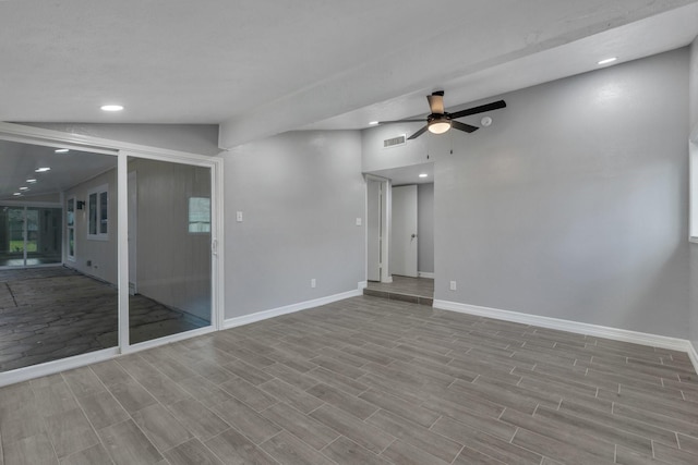 empty room with ceiling fan and vaulted ceiling