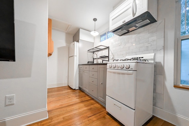 kitchen with gray cabinets, range hood, decorative backsplash, light hardwood / wood-style floors, and white appliances