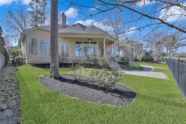 back of house with a yard and ceiling fan