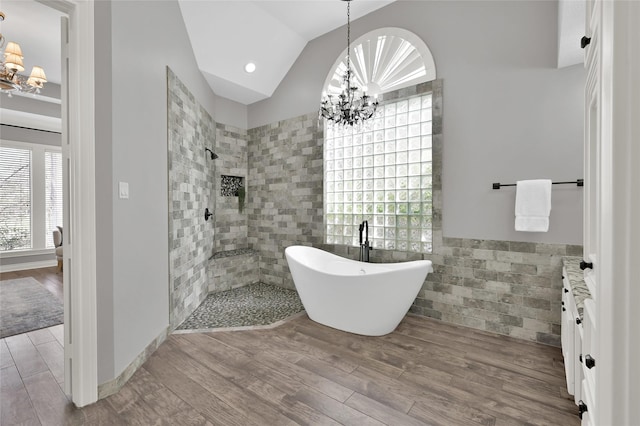 bathroom with lofted ceiling, wood-type flooring, and a notable chandelier