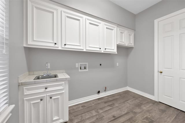 laundry area featuring gas dryer hookup, sink, hardwood / wood-style floors, hookup for a washing machine, and cabinets