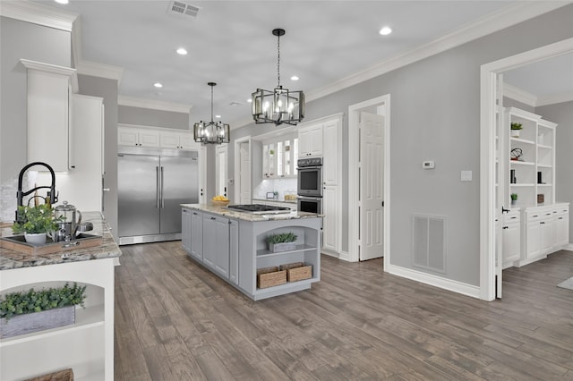 kitchen featuring sink, white cabinetry, decorative light fixtures, a kitchen island, and stainless steel appliances