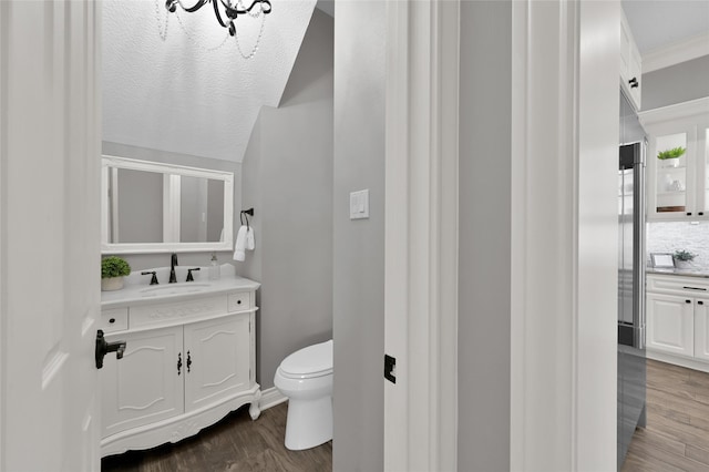 bathroom with vanity, hardwood / wood-style flooring, a textured ceiling, and toilet