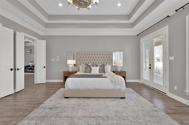 bedroom with a notable chandelier, a tray ceiling, access to exterior, and french doors