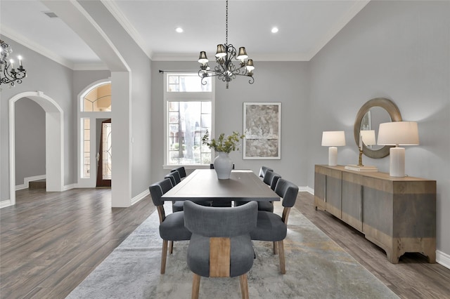 dining area with crown molding, hardwood / wood-style flooring, and a notable chandelier