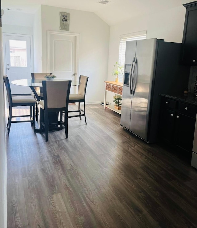 dining room with lofted ceiling and dark wood-type flooring