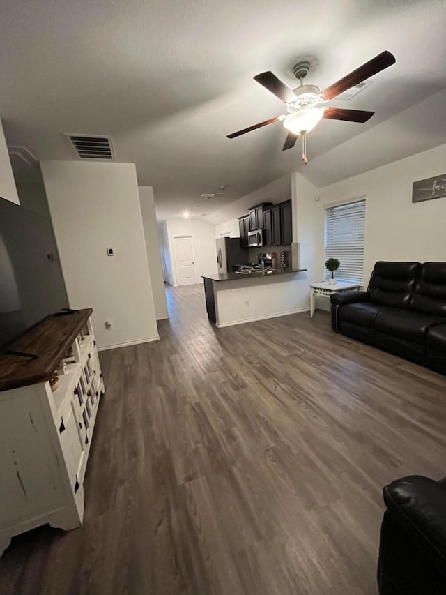 living room with lofted ceiling, dark wood-type flooring, and ceiling fan